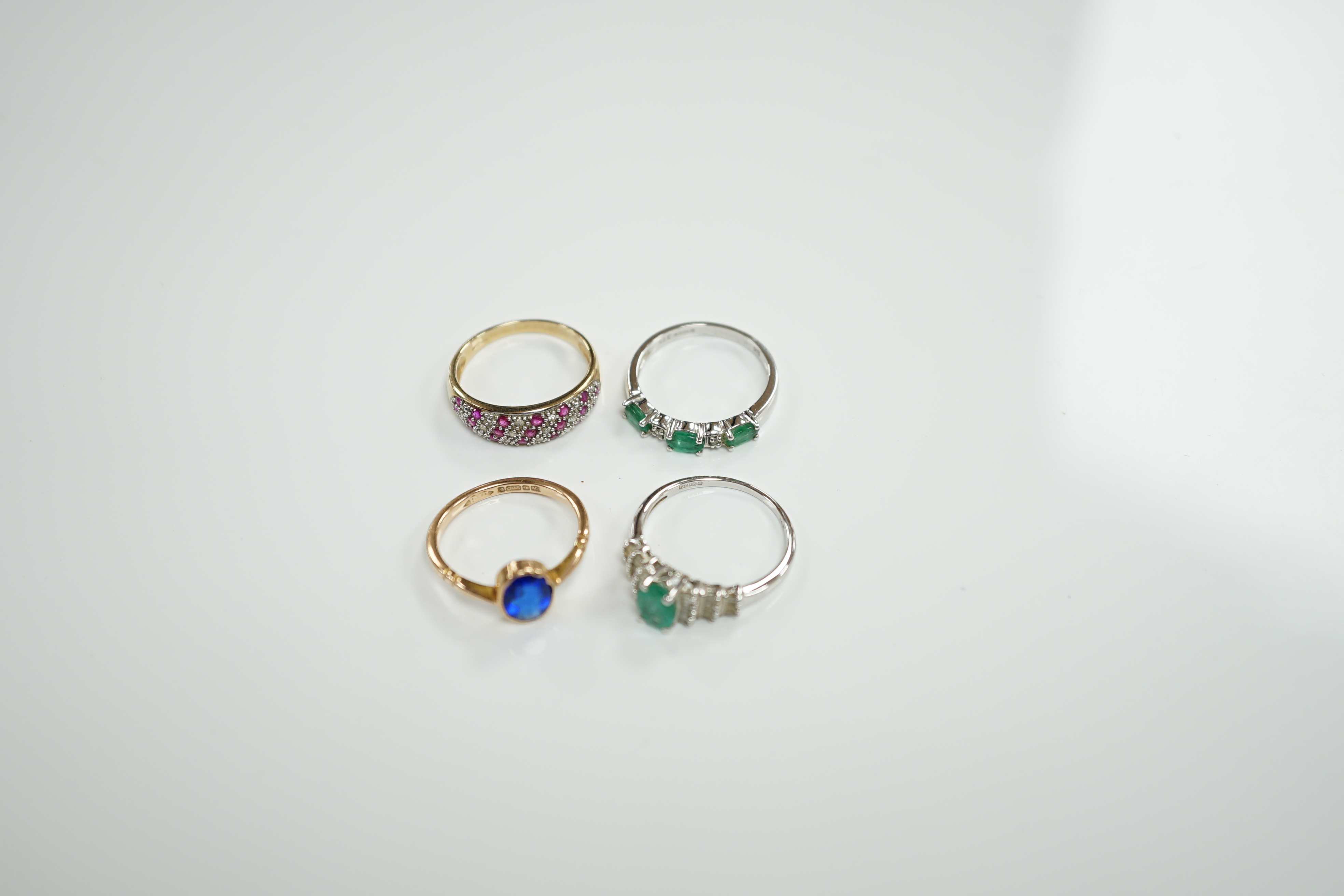 Three assorted modern 9ct gold and gem set rings including emerald and diamond chip set half hoop, size N, gross weight 6.8 grams and a modern14ct white gold and single stone emerald set dress ring, with baguette cut dia